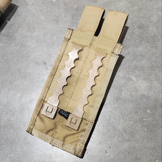 Tan tactical magazine on a concrete floor with a boot in the foreground