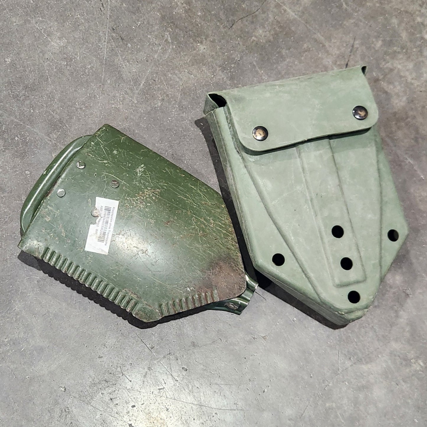 Two green metal parts on a gray tiled floor