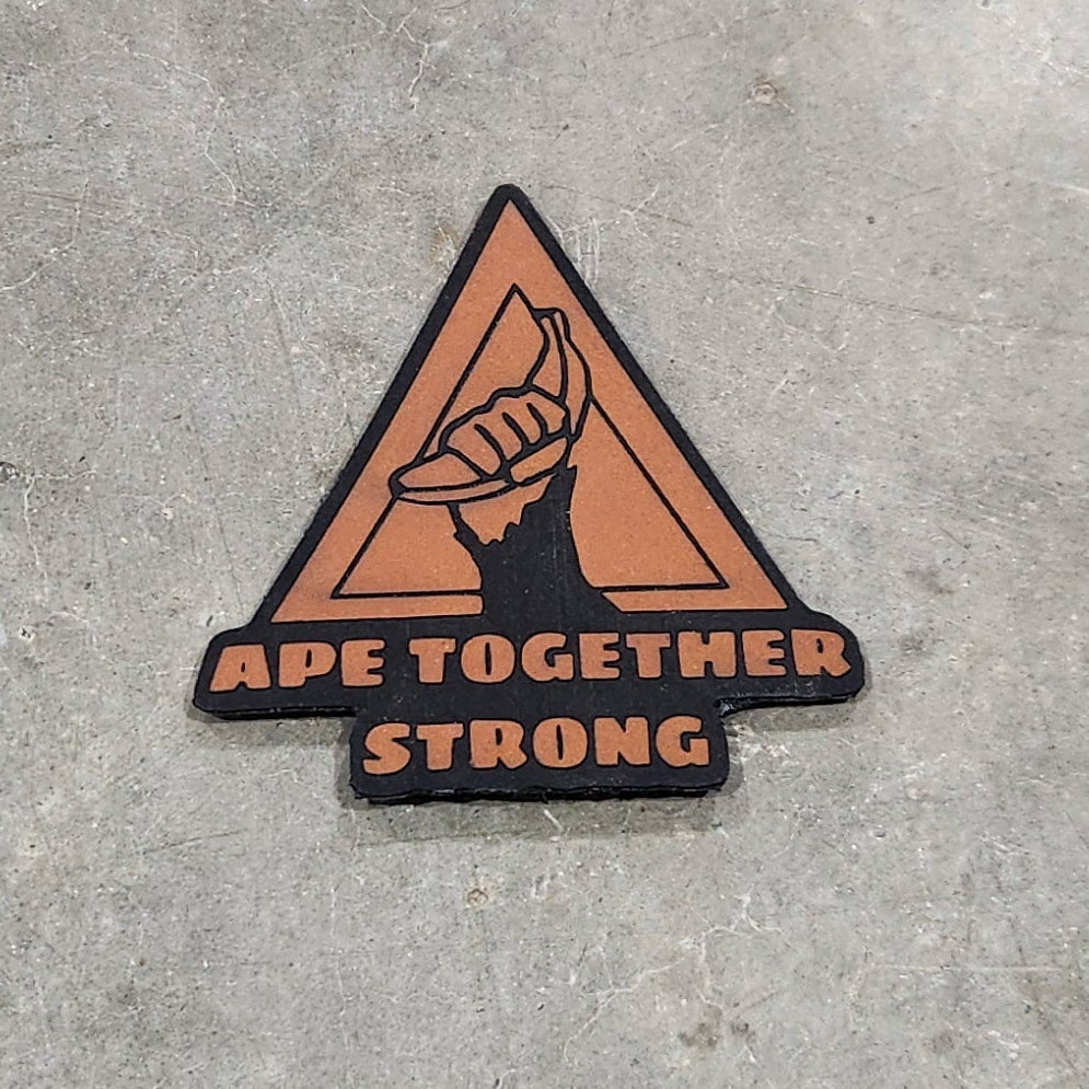 Two orange and black triangular warning stickers on a concrete floor.