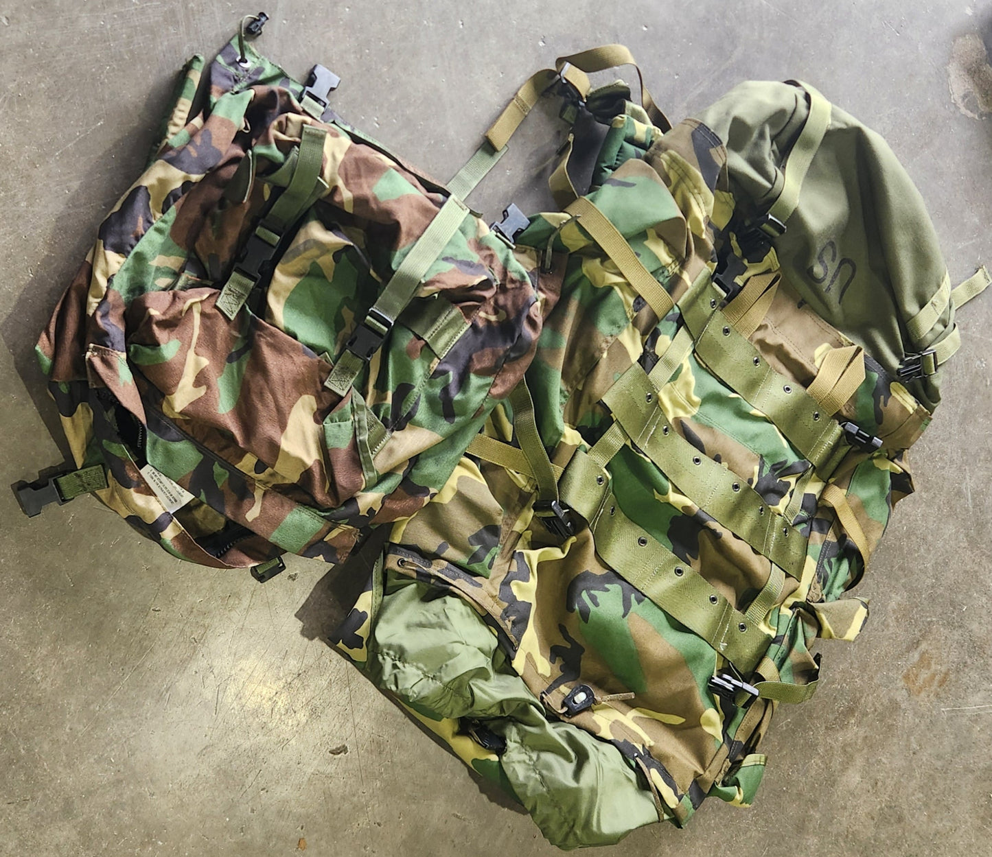 Camouflage-patterned bags on a concrete floor