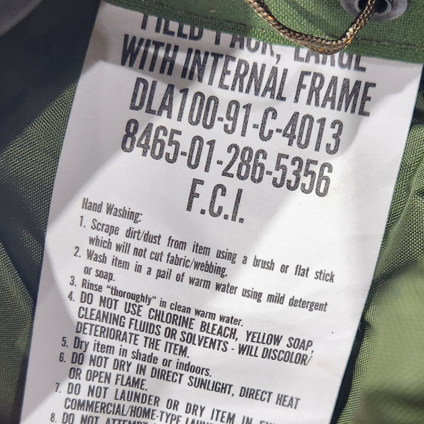 Hand holding a product tag on a green bag