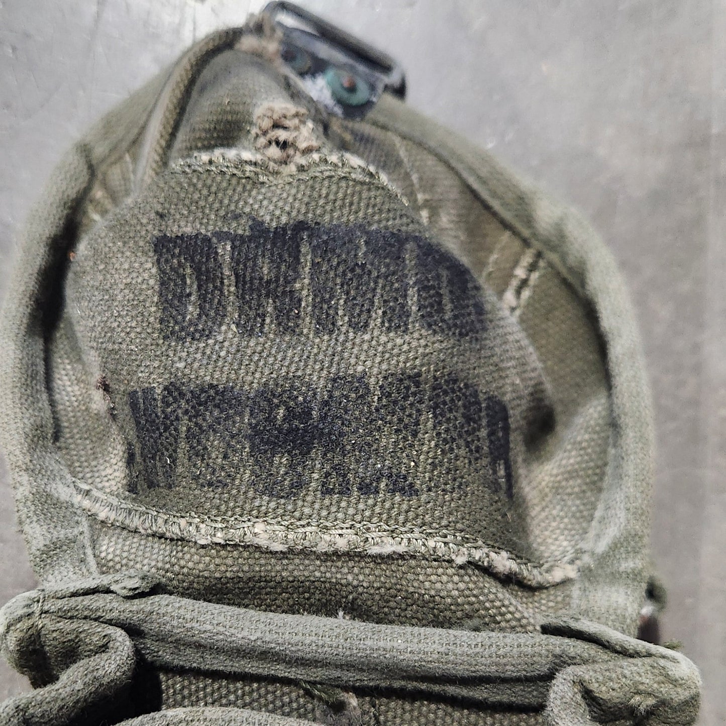 Tan tactical pouch with 'DEMI' branding on a concrete surface