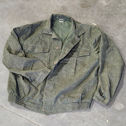Worn green jacket on a concrete floor
