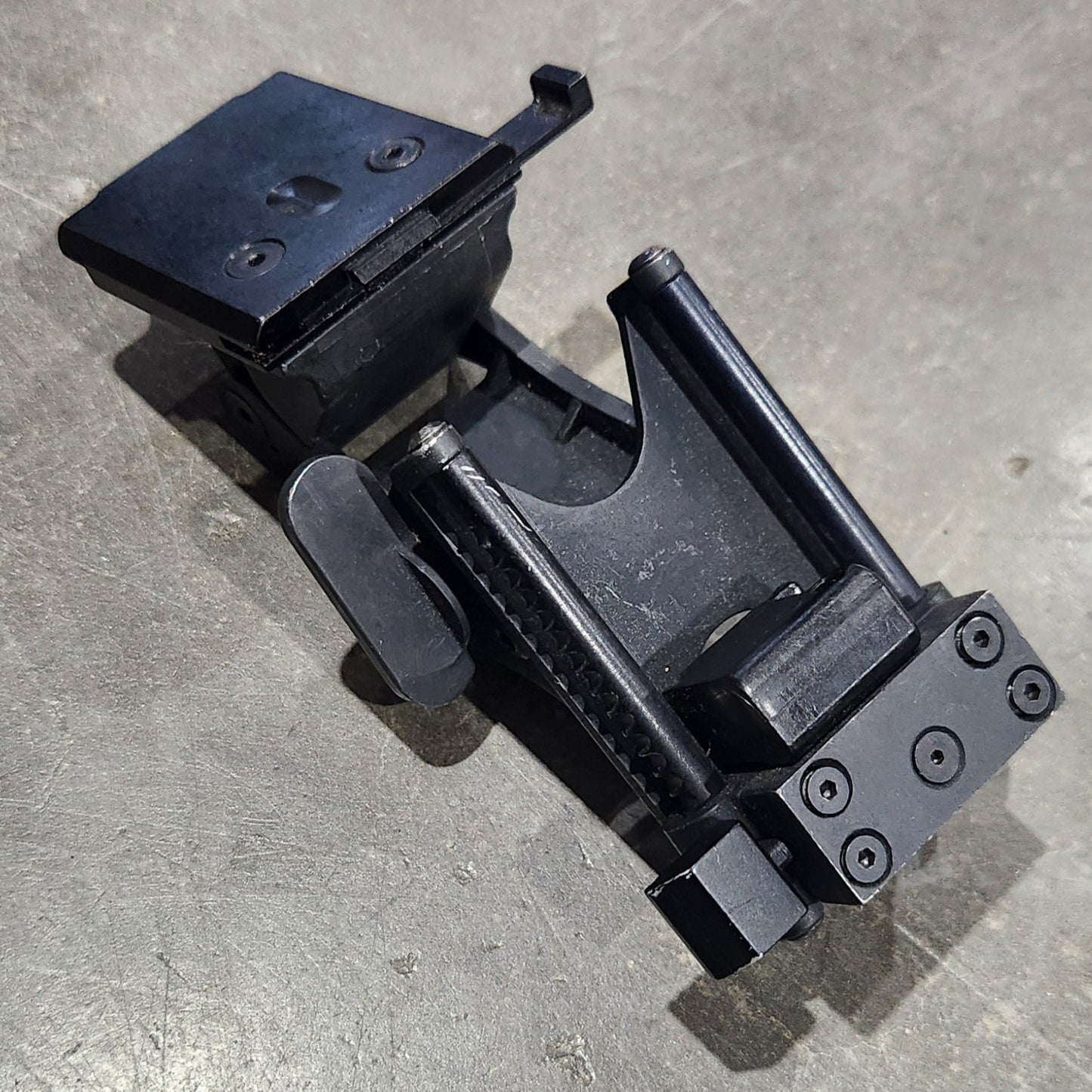 Black metal clamp on a gray concrete surface