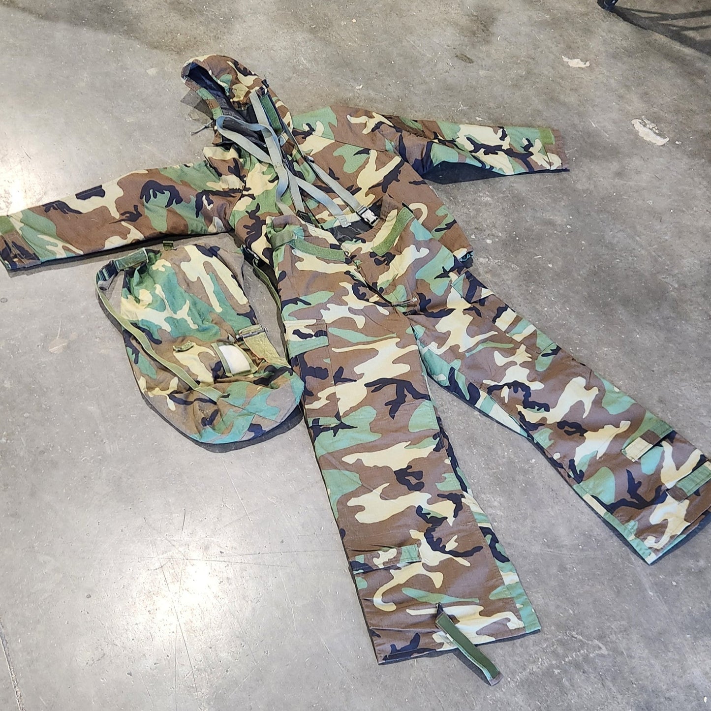 Camouflage-patterned pants on a concrete floor with tools and equipment in the background