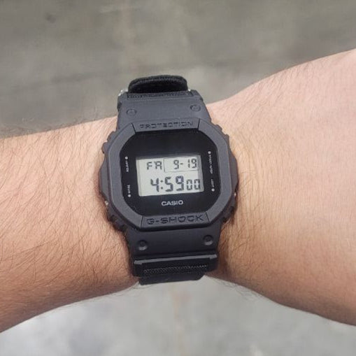 Black digital watch on a wrist with a blurred background