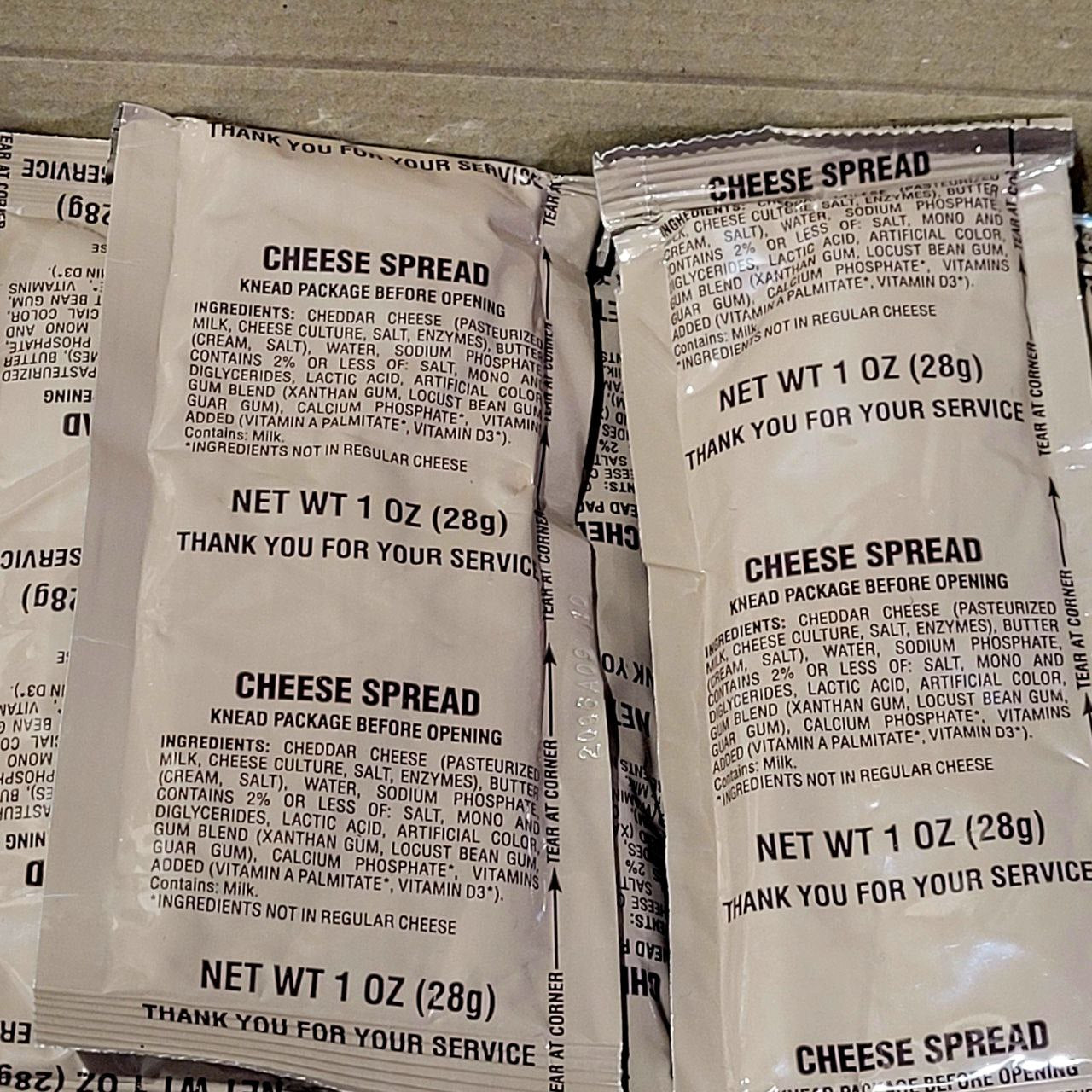 Multiple packages of cheese spread with text on a gray surface