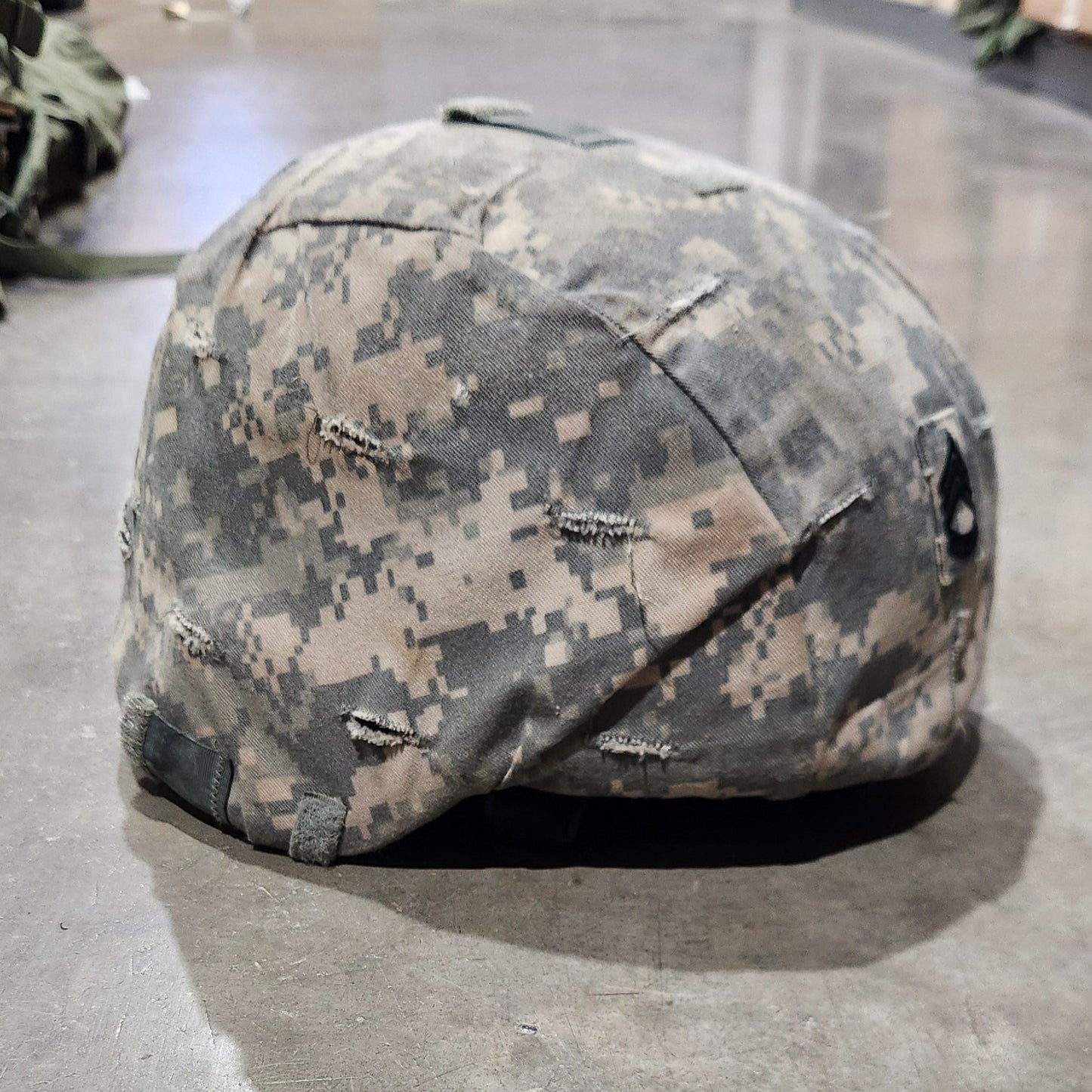 Camouflage helmet on a concrete floor