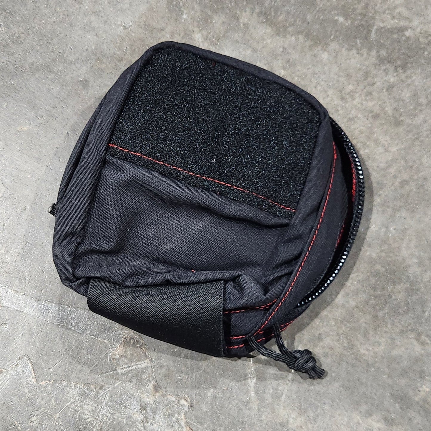 Black pouch on a gray concrete surface