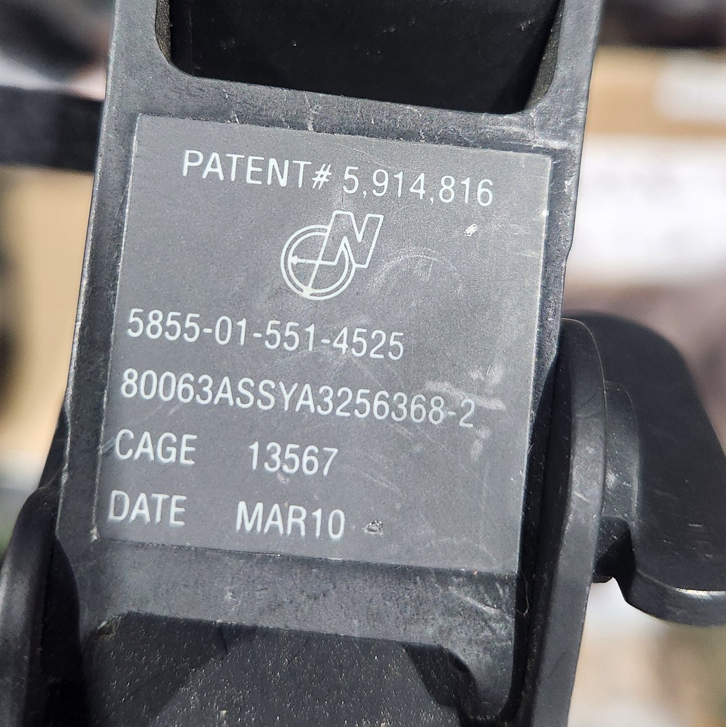 Close-up of a black metal cage with engraved text on a blurred background