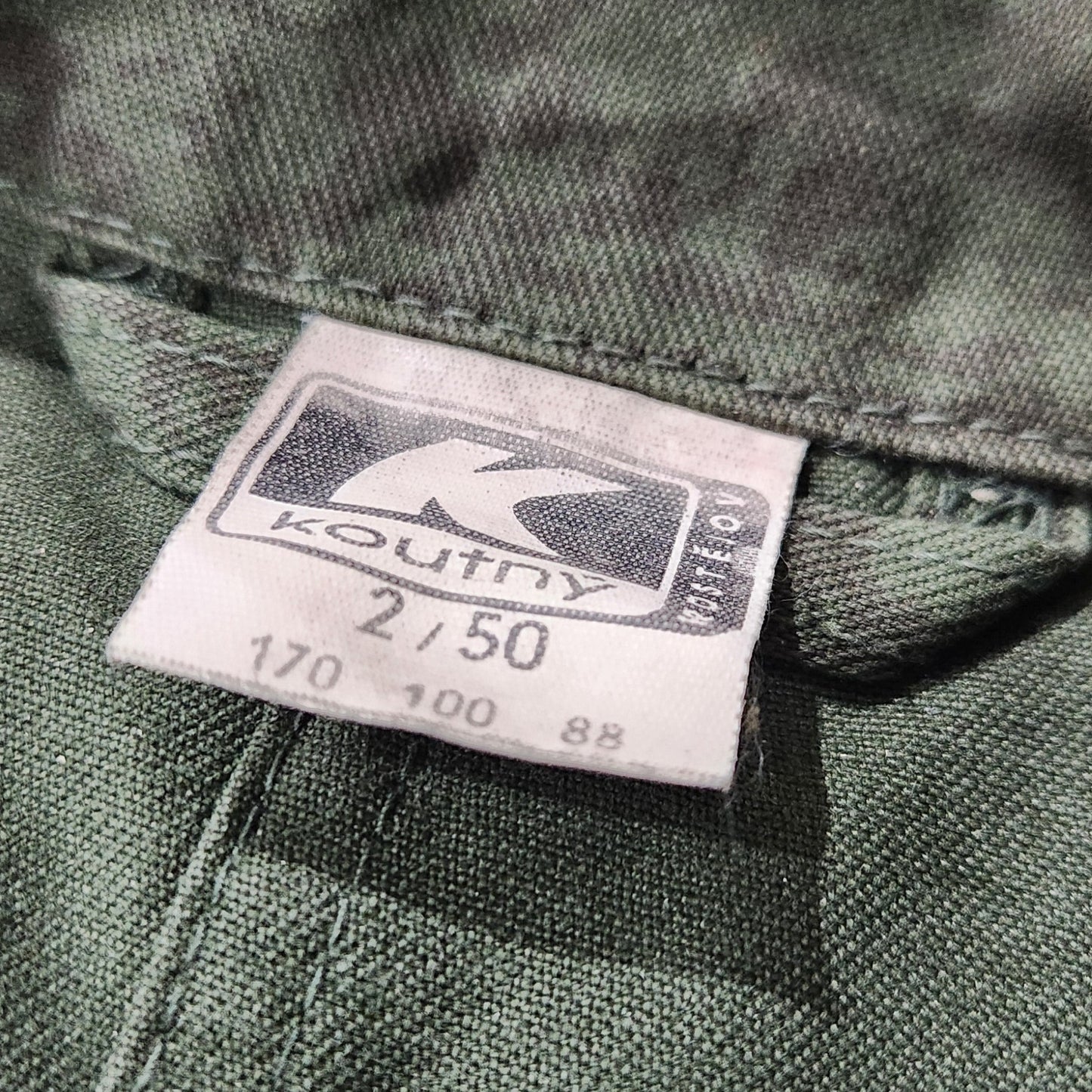 Close-up of a clothing tag on a green fabric background
