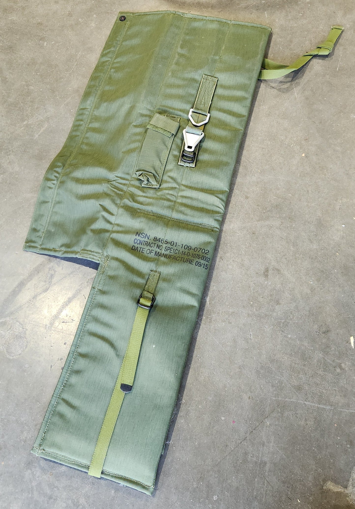 Green tool roll with a strap on a concrete floor