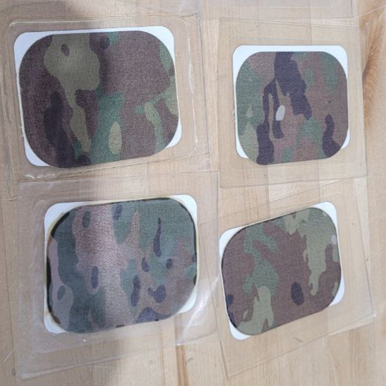 Camouflage-patterned square stickers on a wooden surface