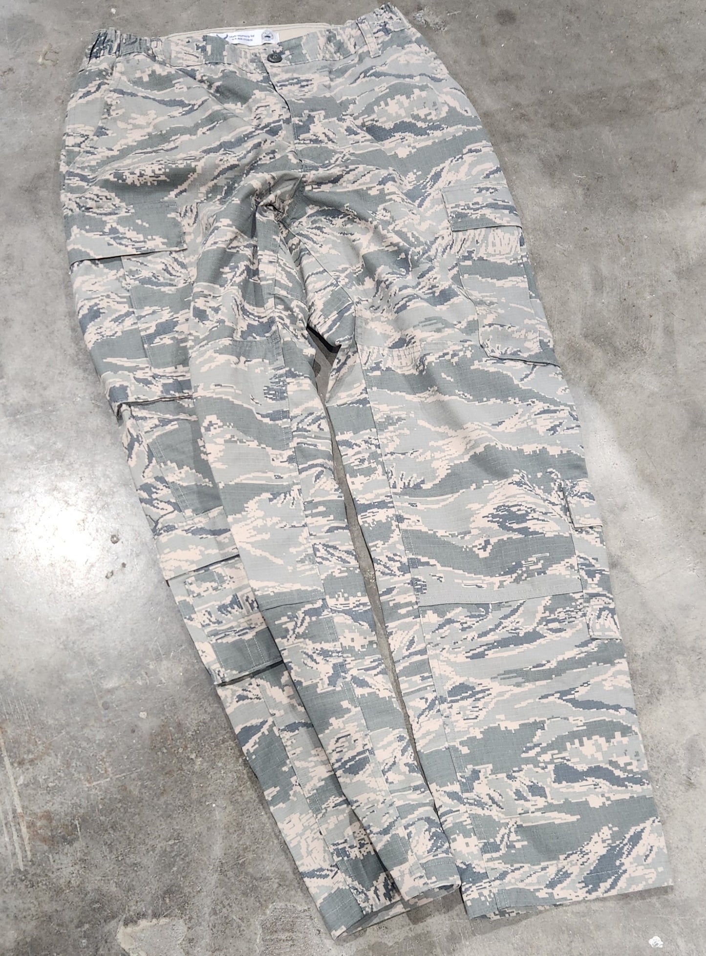 ABU Camouflage-patterned pants on a concrete floor