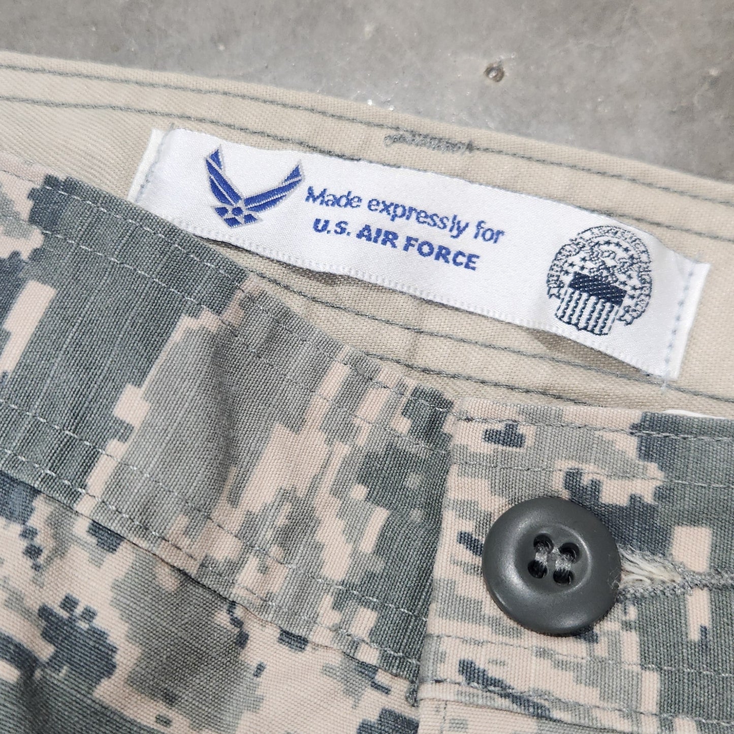 Camouflage uniform with a label on a concrete surface