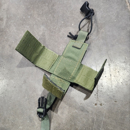 Green tactical pouch on a gray concrete floor