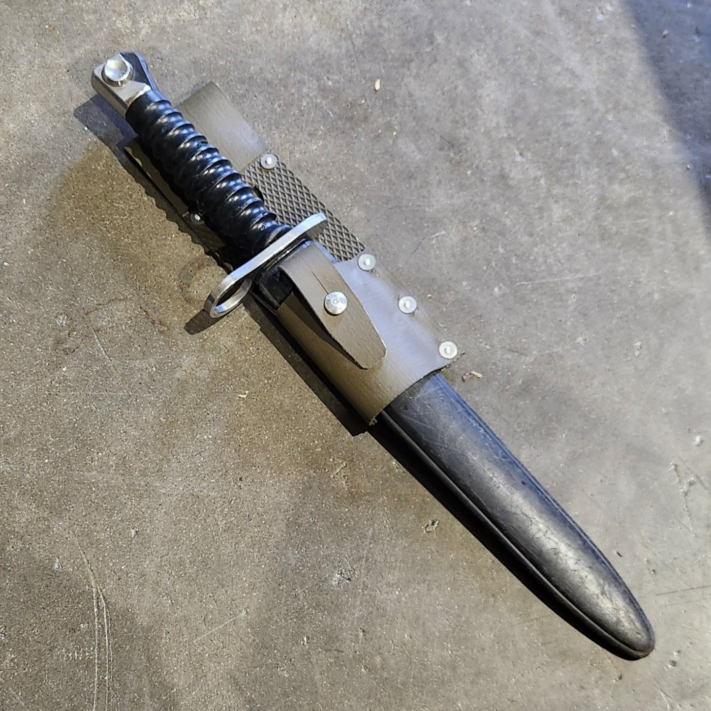 Dagger with sheath on a concrete floor