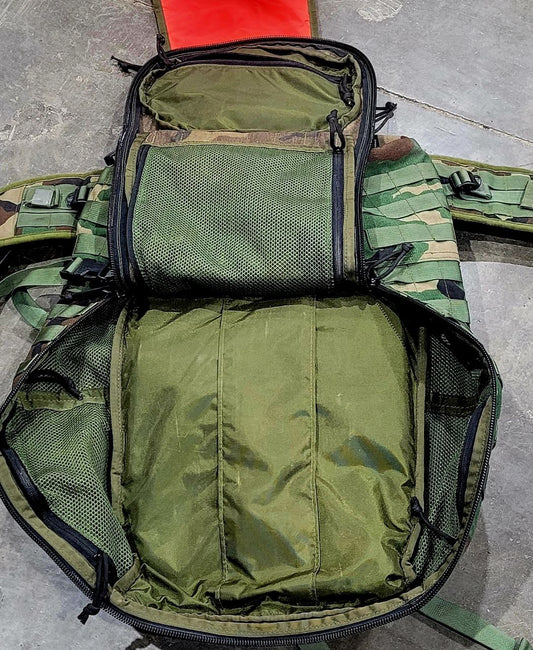 Green tactical backpack on a gray surface