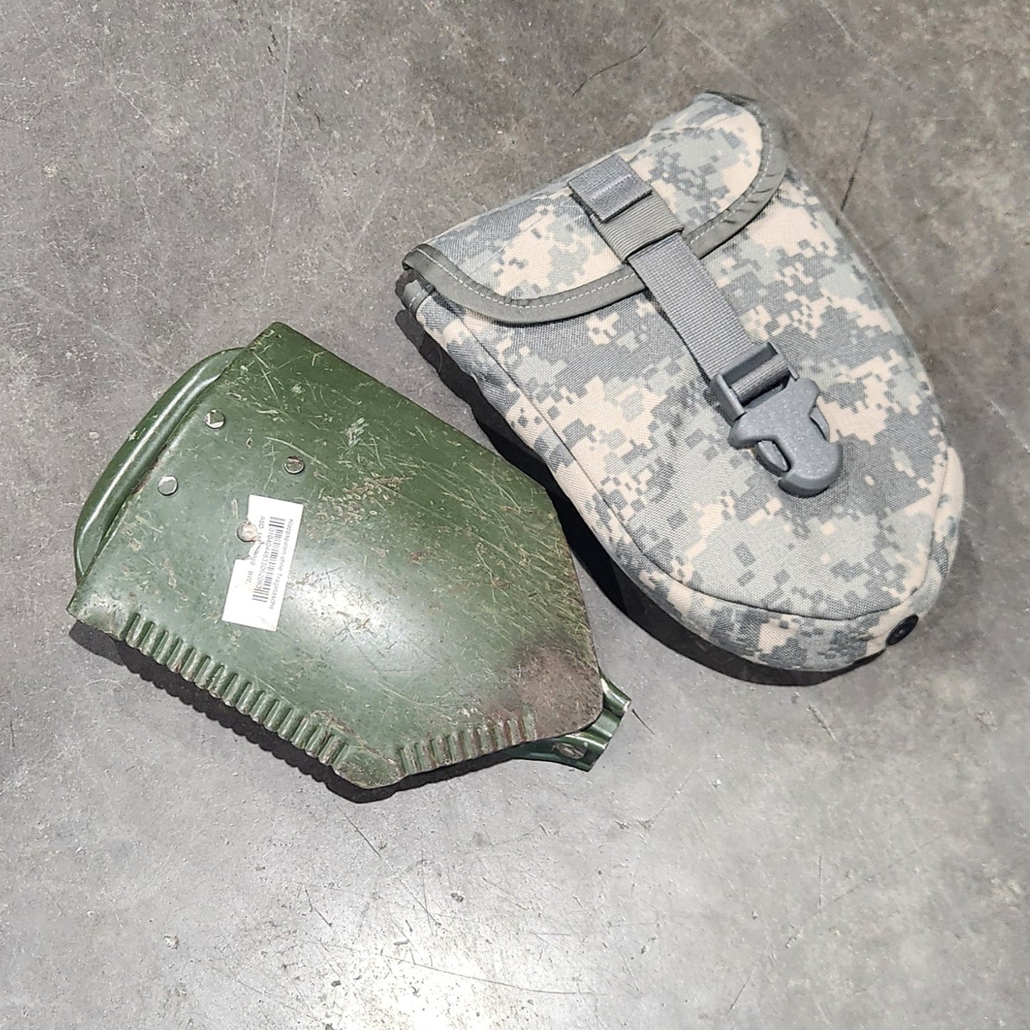 Two green military-style pouches on a gray floor.