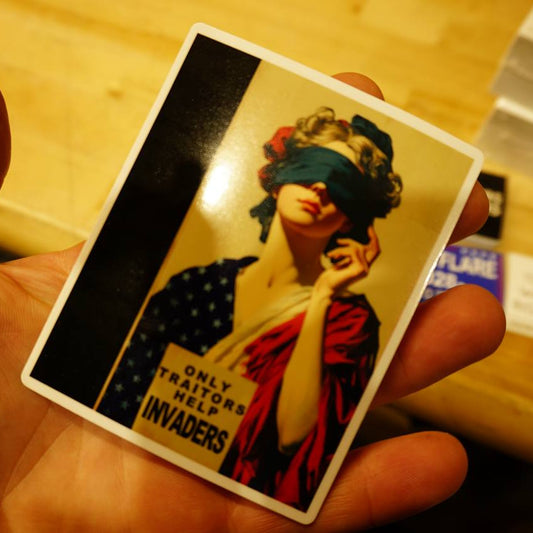 Hand holding a vintage-style card with a stylized portrait and text on a wooden surface.