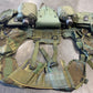 Green tactical vest with multiple pouches and equipment on a gray surface