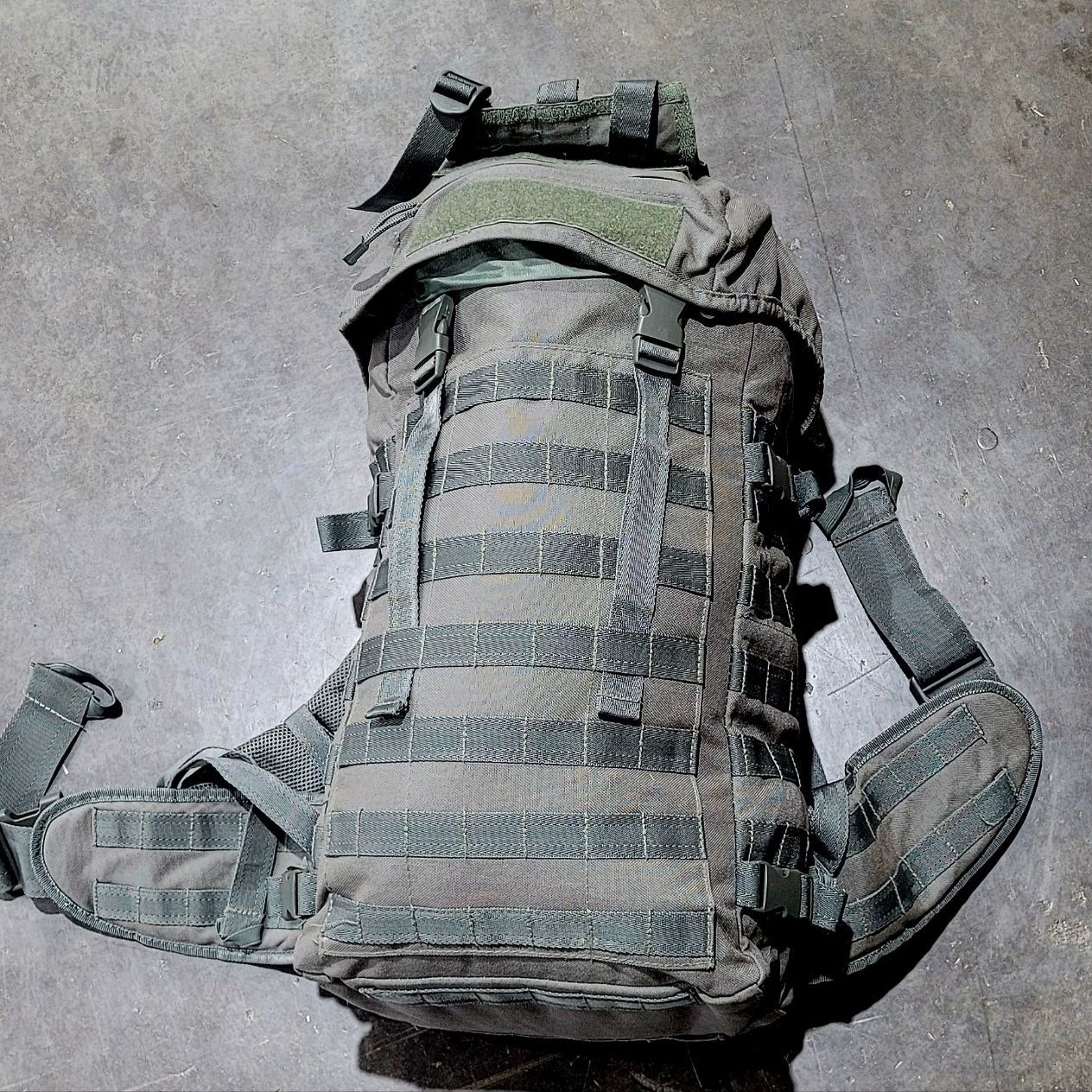 Tactical backpack on a gray concrete floor