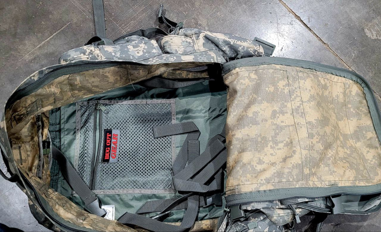 Camouflage backpack with visible branding on a gray floor