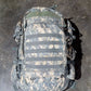 Camouflage backpack on a dark textured surface