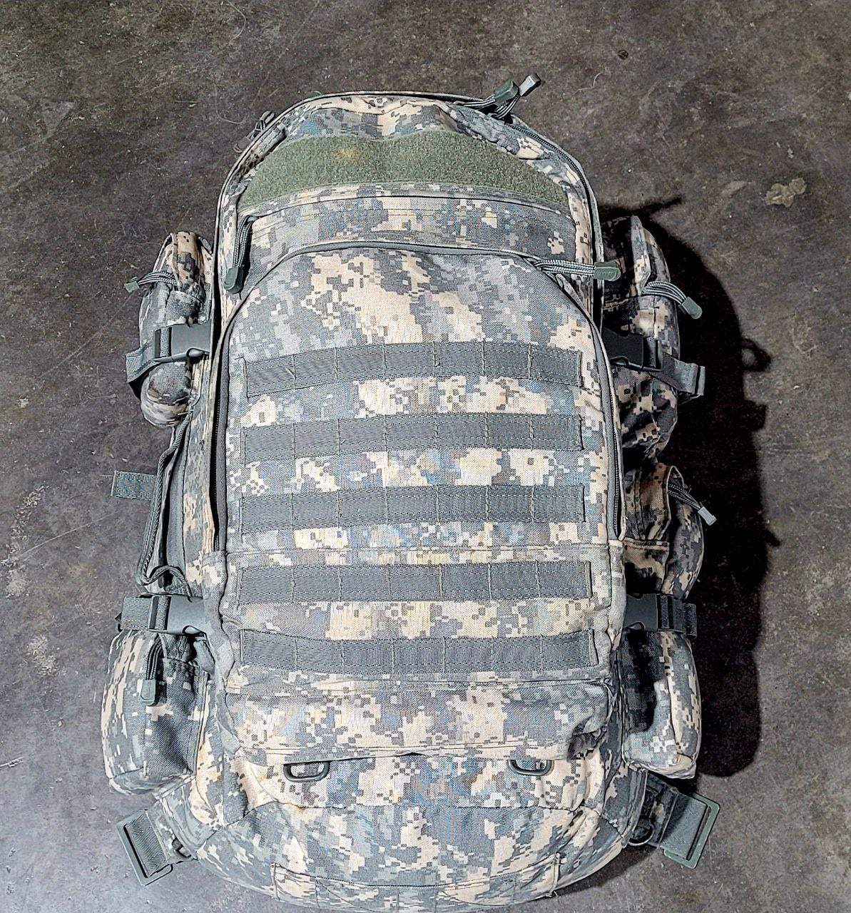 Camouflage backpack on a dark textured surface