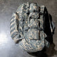Camouflage backpack on a dark surface