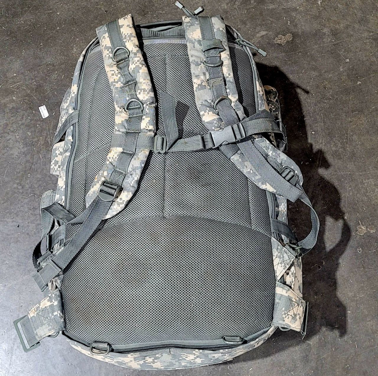 Tactical backpack with ACU camouflage pattern on a dark surface