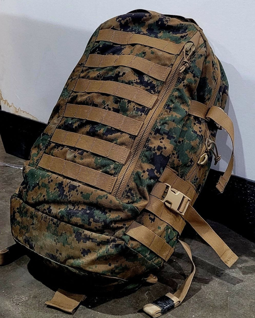 Camouflage backpack with brown straps on a white background