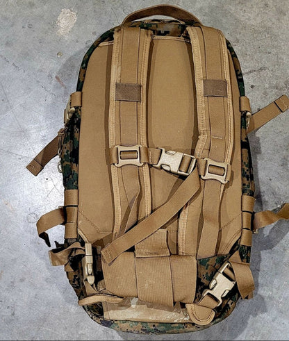 Tan tactical backpack with camouflage pattern on a concrete floor