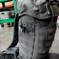 Gray tactical backpack in a warehouse setting