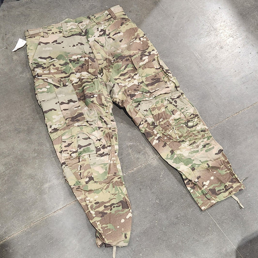 Camouflage pants on a concrete floor with a tool box and equipment in the background.