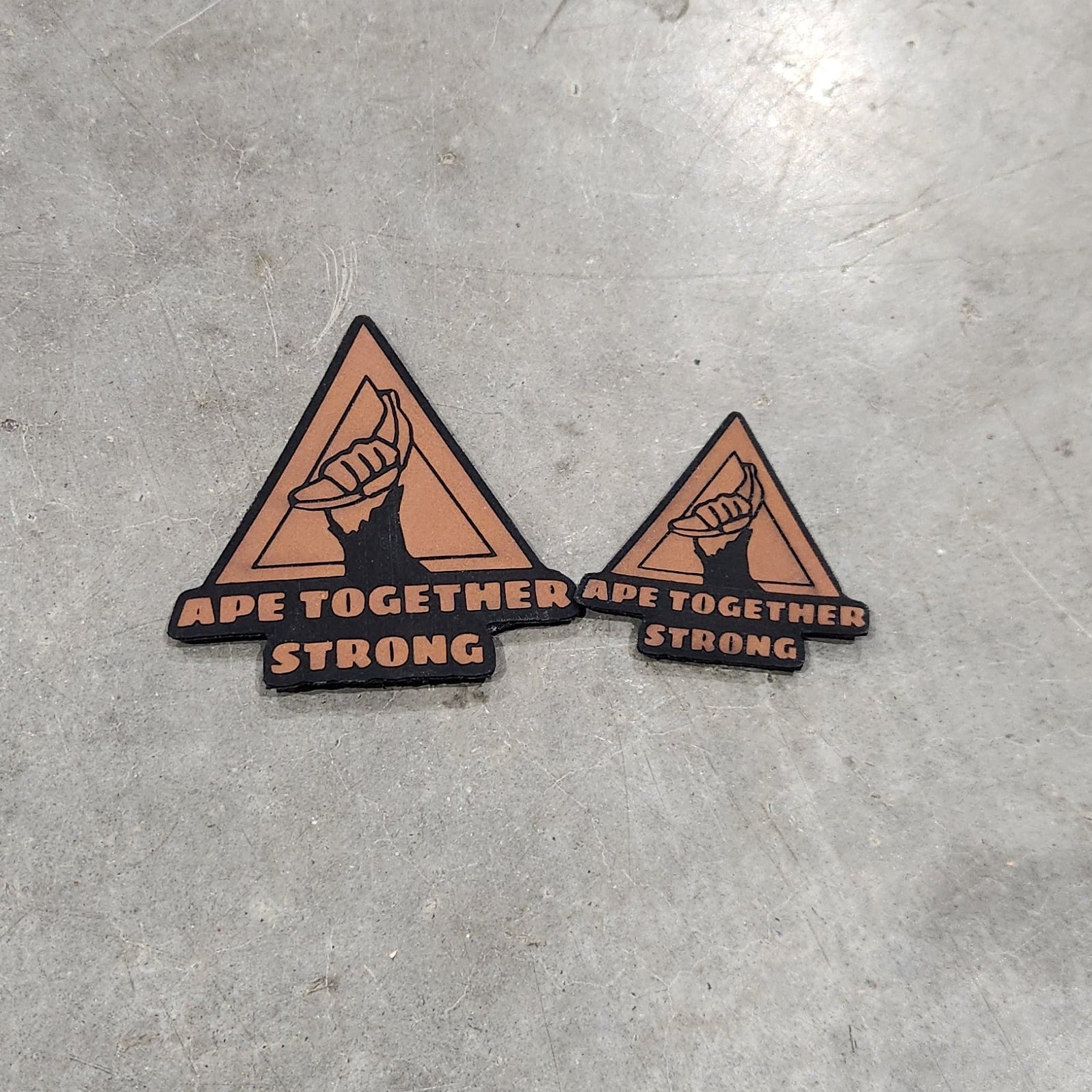 Two triangular stickers on a concrete surface