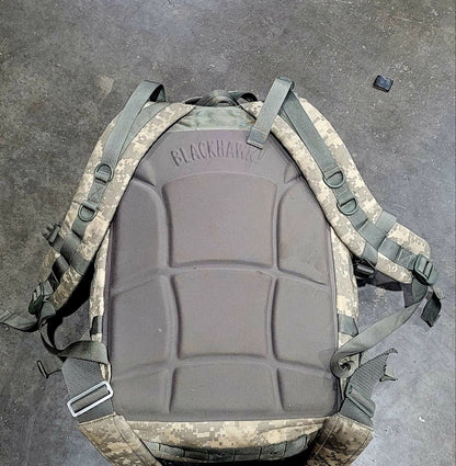 Tactical backpack with camouflage pattern on a gray surface