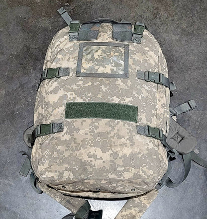 Camouflage backpack with multiple straps on a gray surface