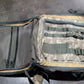 Camouflage backpack with multiple straps on a gray surface