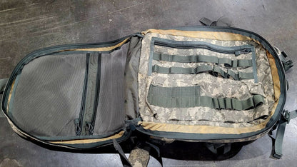 Camouflage backpack with multiple straps on a gray surface