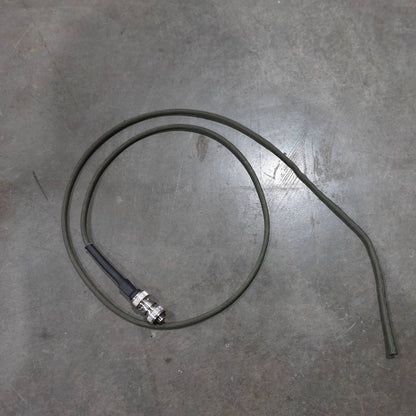 Coiled cable with a metal connector on a gray concrete floor