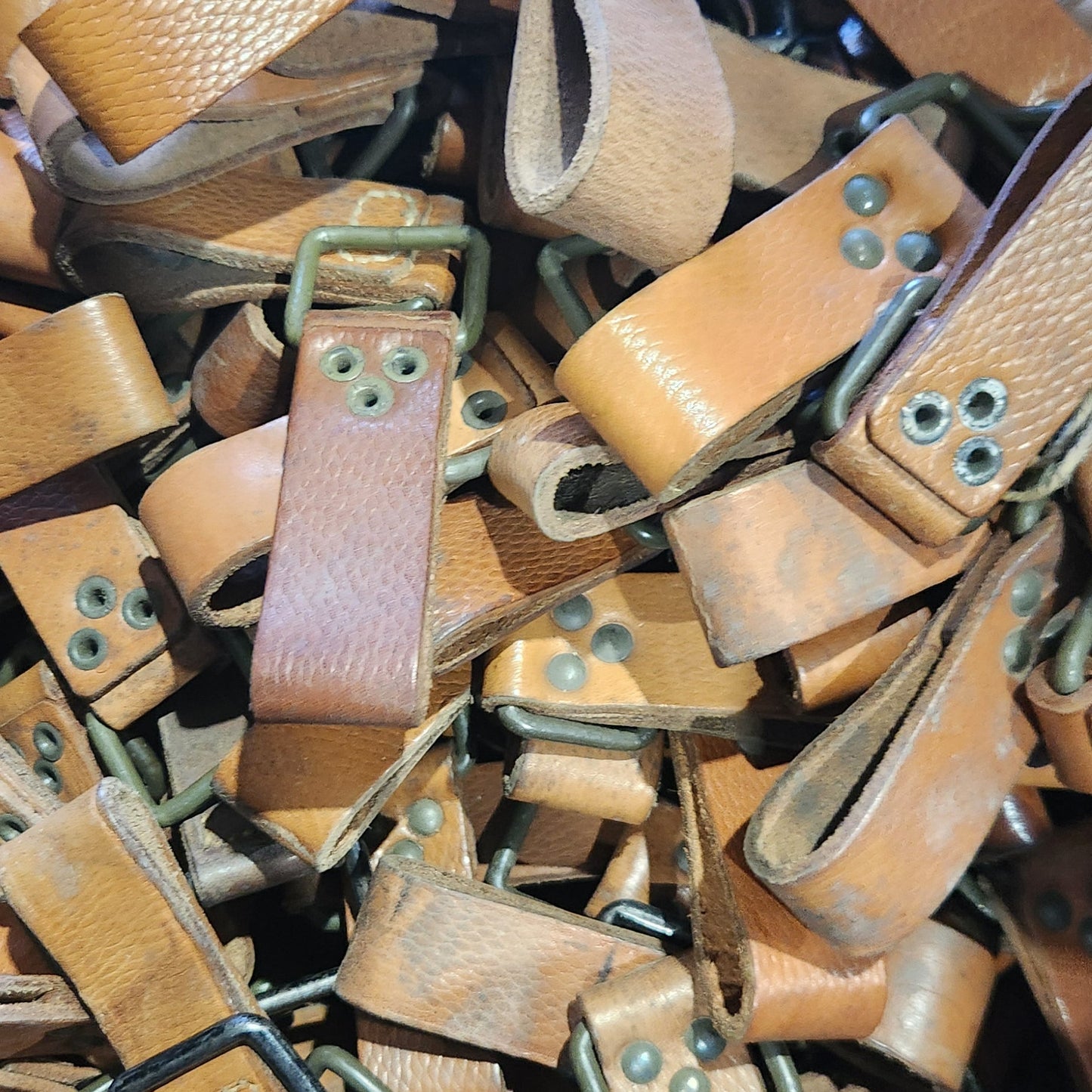 Pile of brown leather straps with buckles