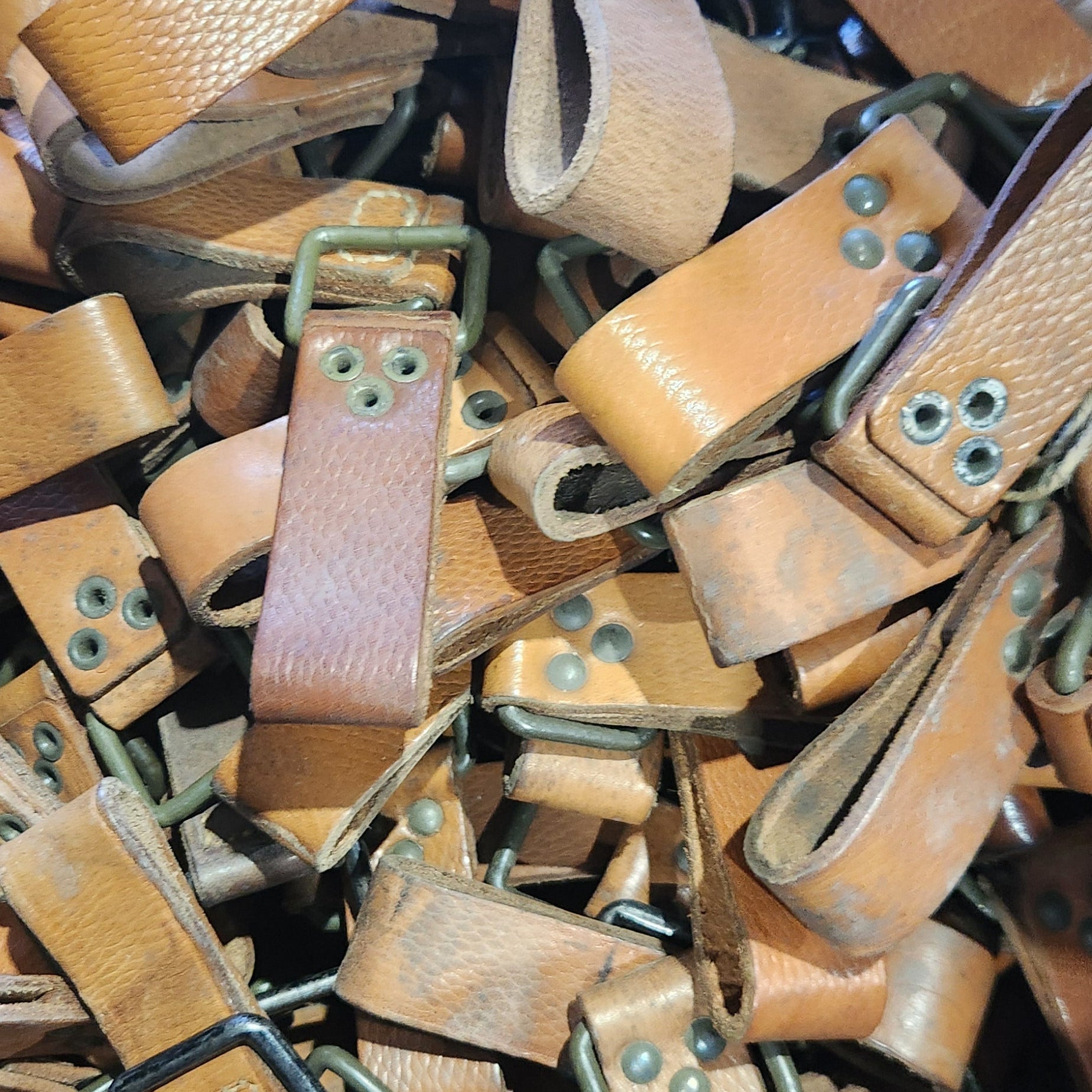 Pile of brown leather straps with buckles