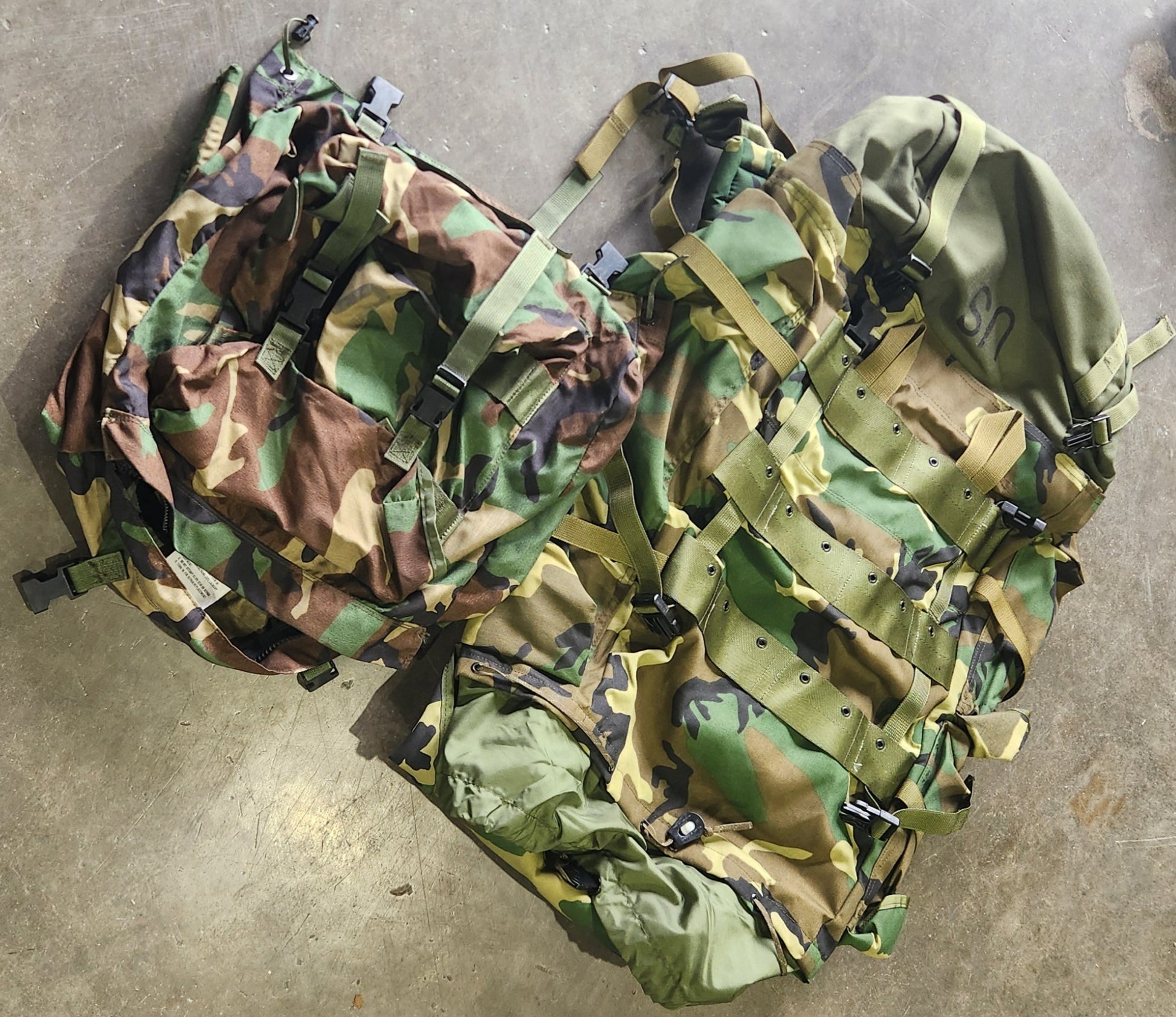 Camouflage-patterned bags on a concrete floor
