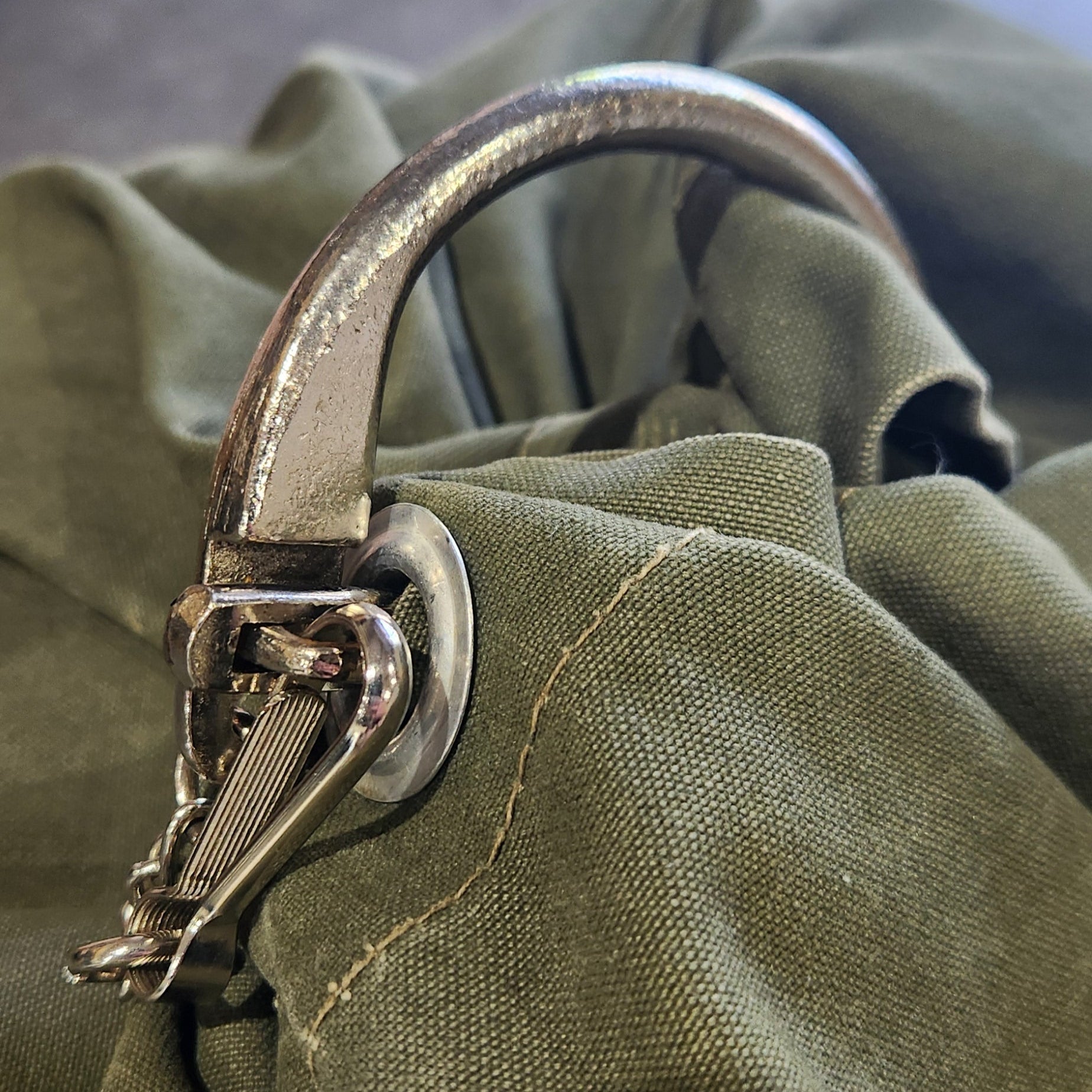 Close-up of a green fabric with a locking bar, blurred background