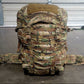 Camouflage backpack on a concrete floor with a metal door in the background
