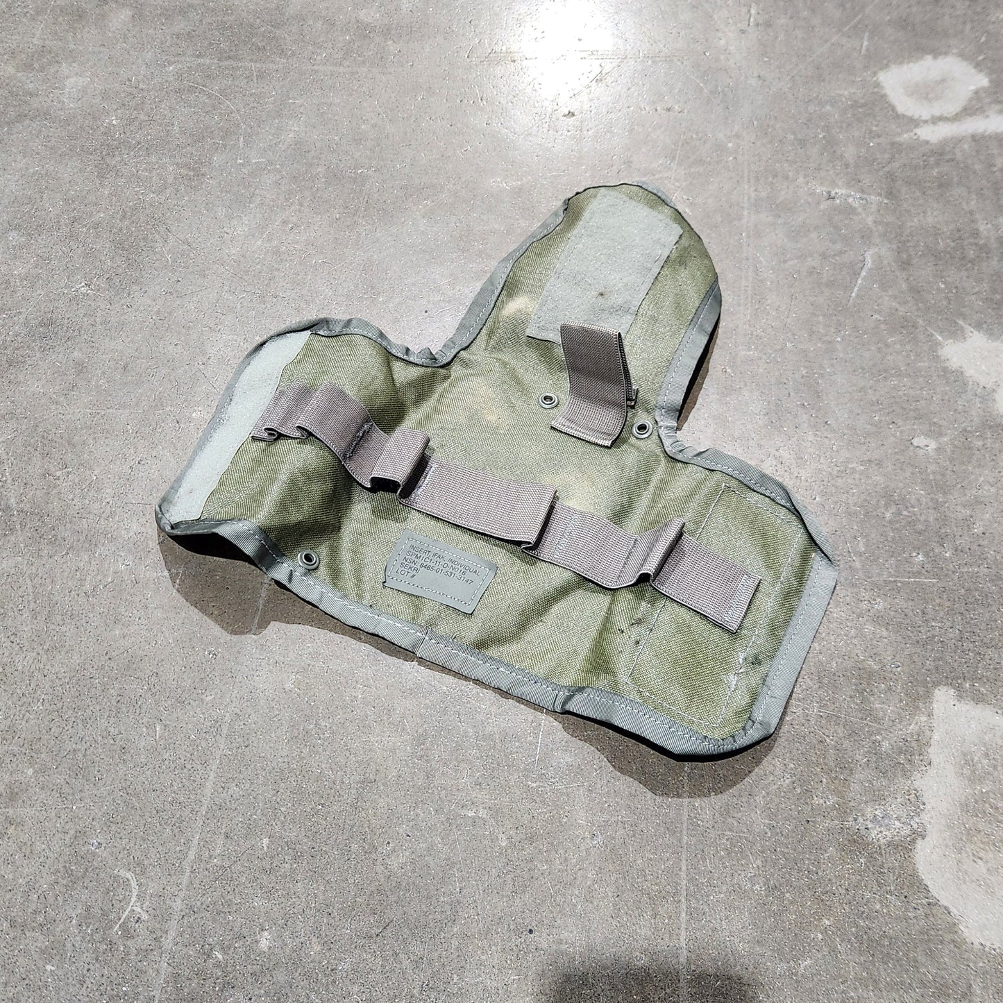 Camouflage-patterned pouch on a concrete floor