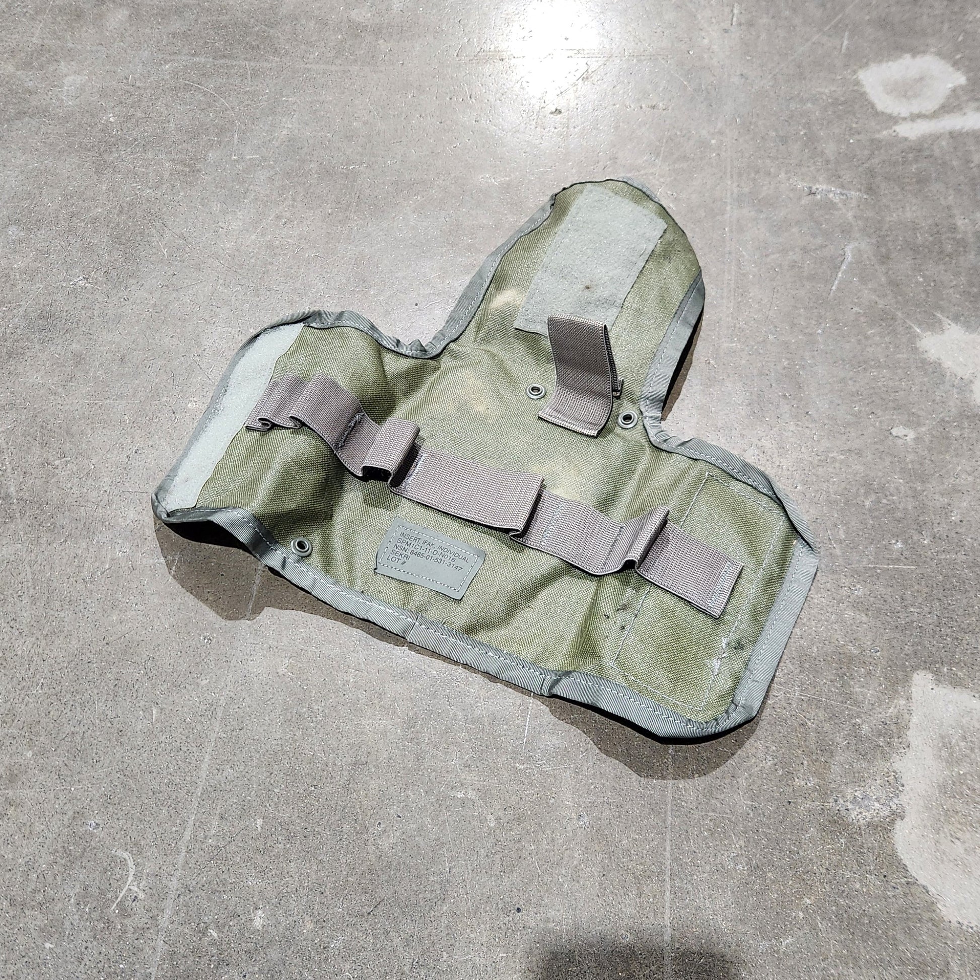 Camouflage-patterned pouch on a concrete floor