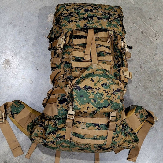 Camouflage backpack with brown straps on a gray concrete floor
