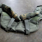 Green tactical vest with camouflage padding on a gray surface